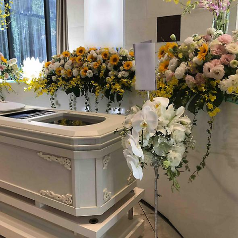 周りに献花が供えられた棺