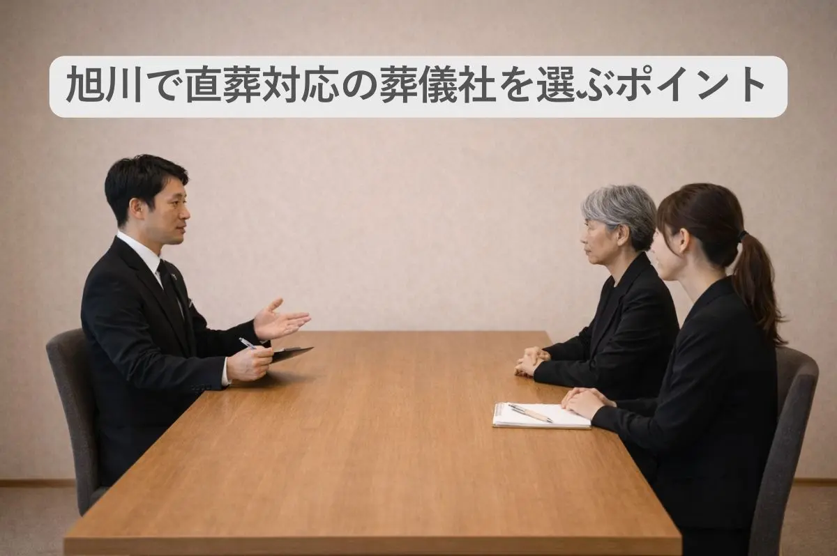 葬儀社と遺族がテーブルについて話をする画像と「旭川で直葬対応の葬儀社を選ぶポイント」の文字