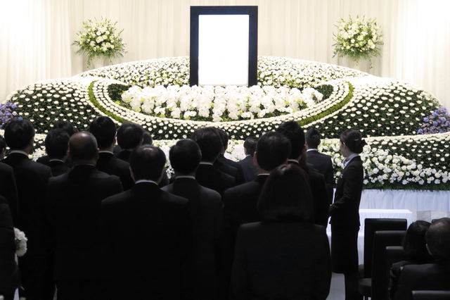 社葬に参列する人々と祭壇の画像