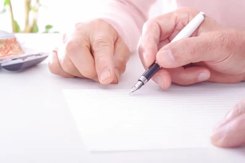 通夜の喪主挨拶を便箋に書くシニアの手元の画像